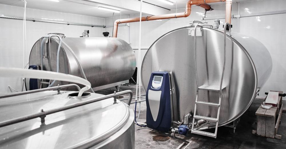 Bulk tanks sit side by side, with a ladder attached to one of them. A control unit and piping connect to the tanks.