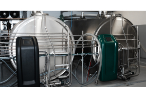 Two milk cooling tanks placed next to each other with a black and green terminal on the left and right, respectively.